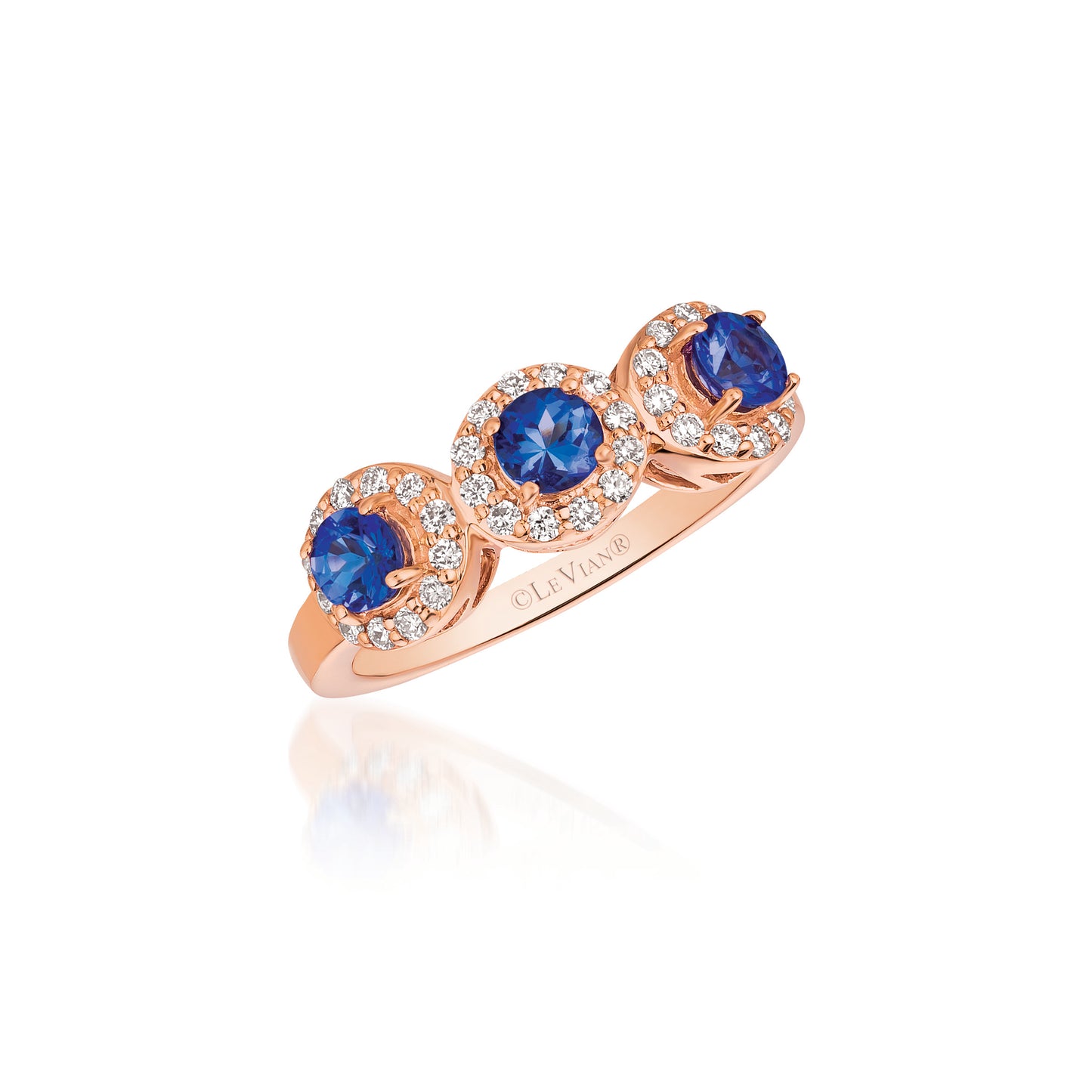 A Le Vian Ring from BirthStone.com showcases a 14K Strawberry Gold band adorned with three Blueberry Tanzanite stones encircled by Vanilla Diamonds, offering an elegant and sophisticated design.