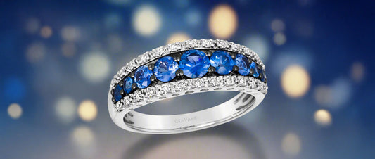 White gold and blue sapphire ring with a sparkly sky background