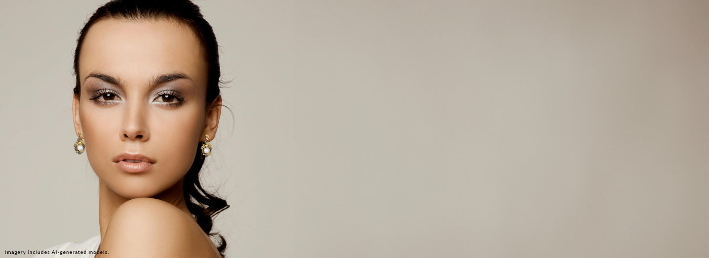 Woman with styled hair and earrings against a plain background