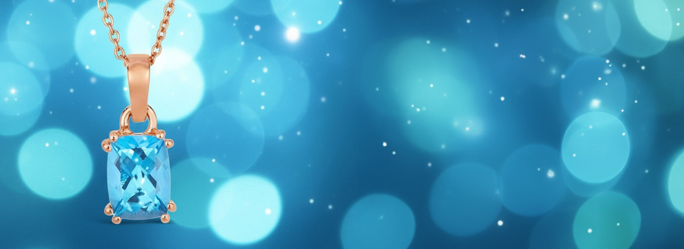 Necklace with a blue gemstone pendant on a blue bokeh background December Topaz Birthstone