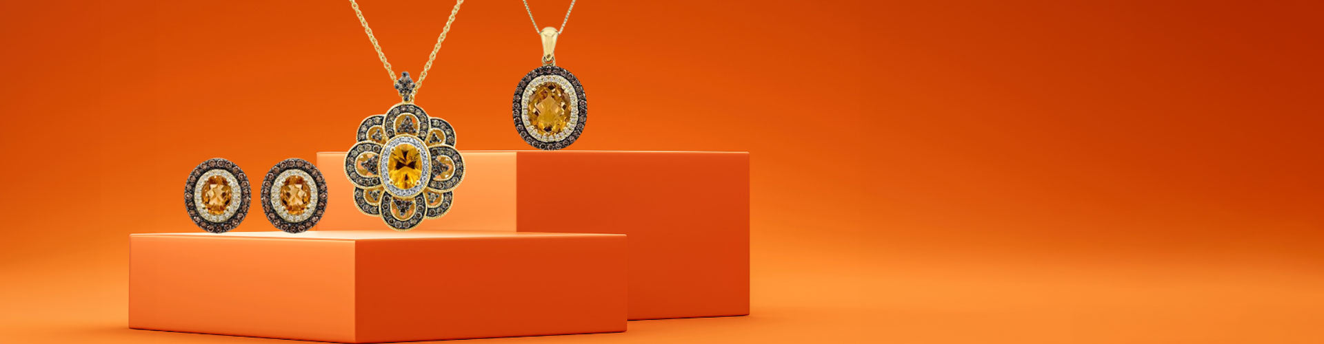 Jewelry collection promotion featuring earrings and necklaces with yellow gemstones on an orange background. Text reads "Falling for November" and "Discover the Collection.